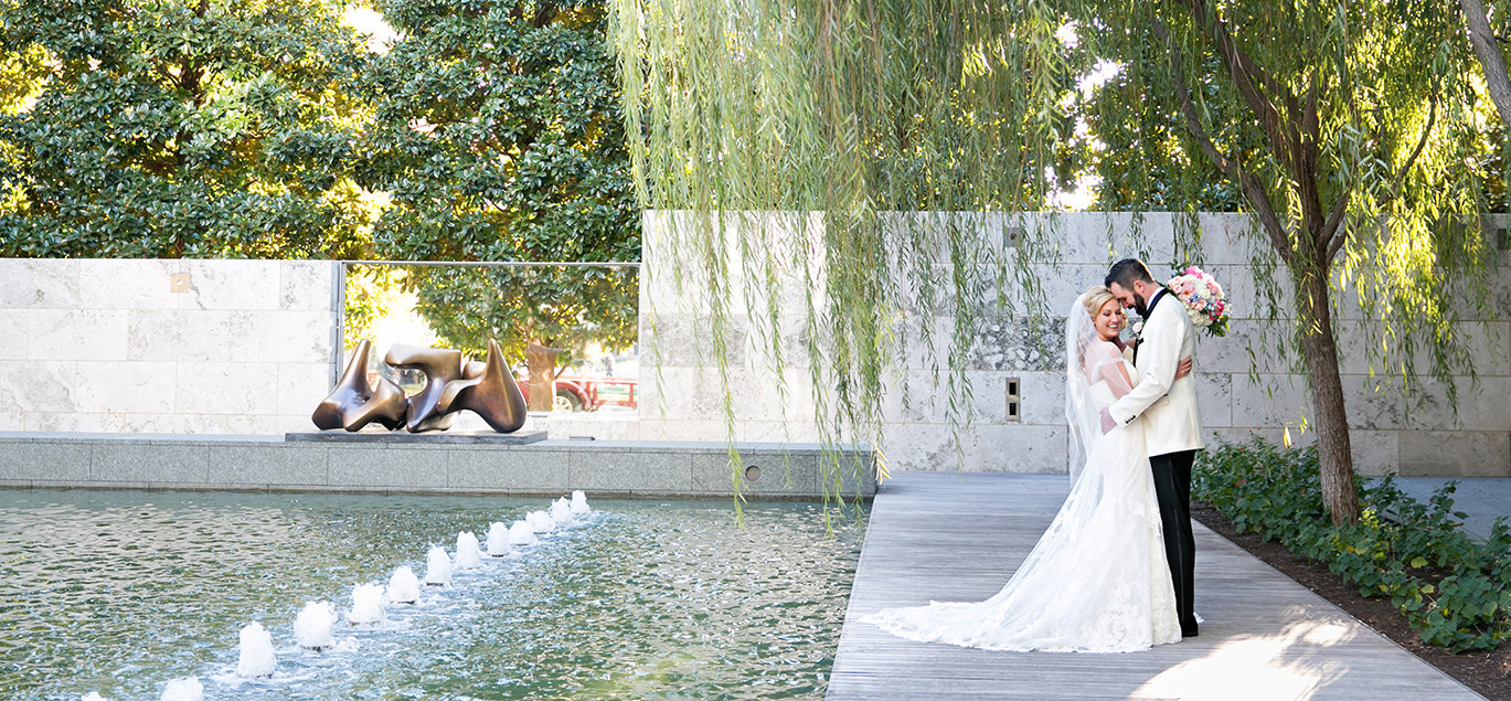 Couple portrait beside a reflecting pool at a Dallas sculpture venue