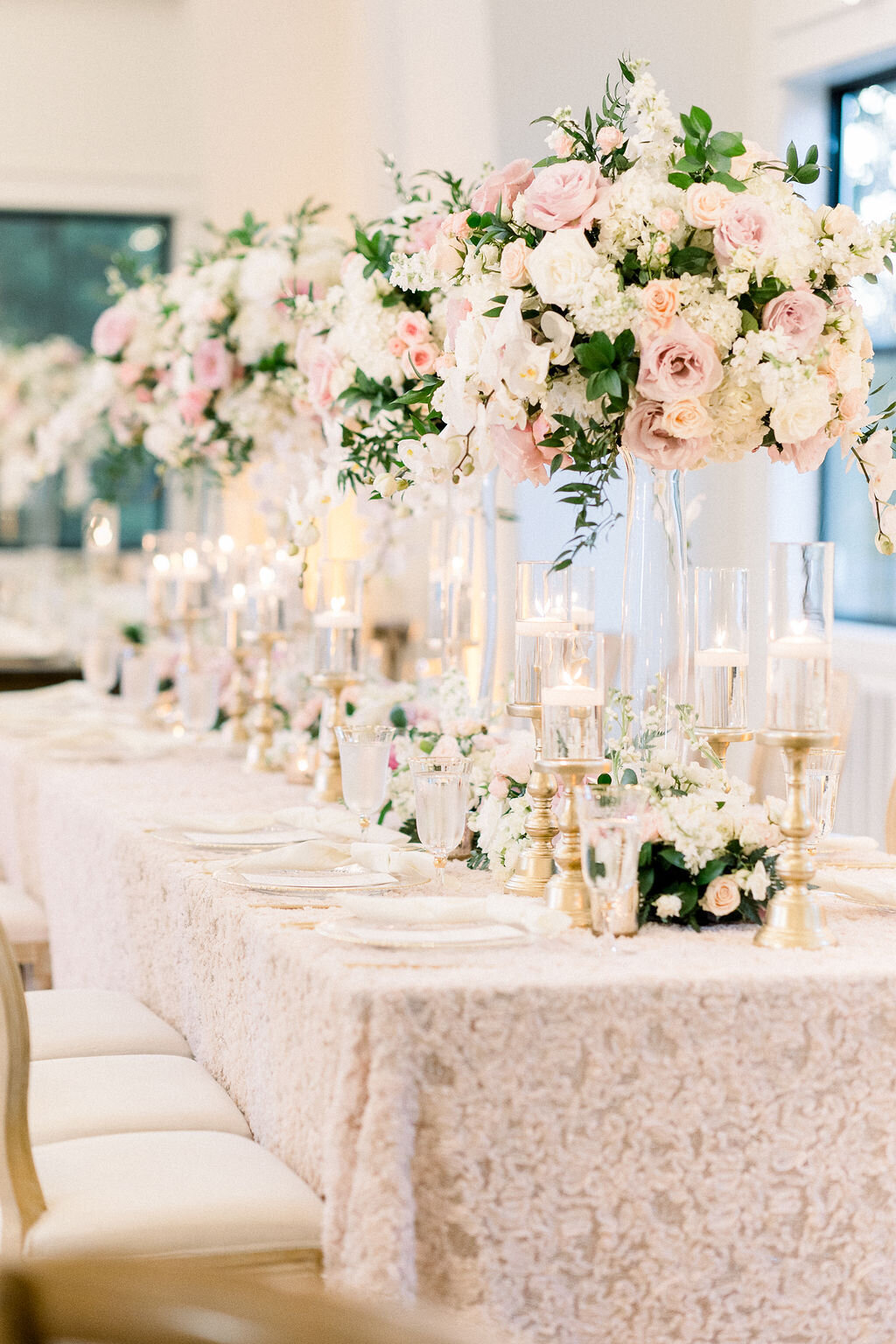Elegant head table with tall centerpieces and soft candlelight