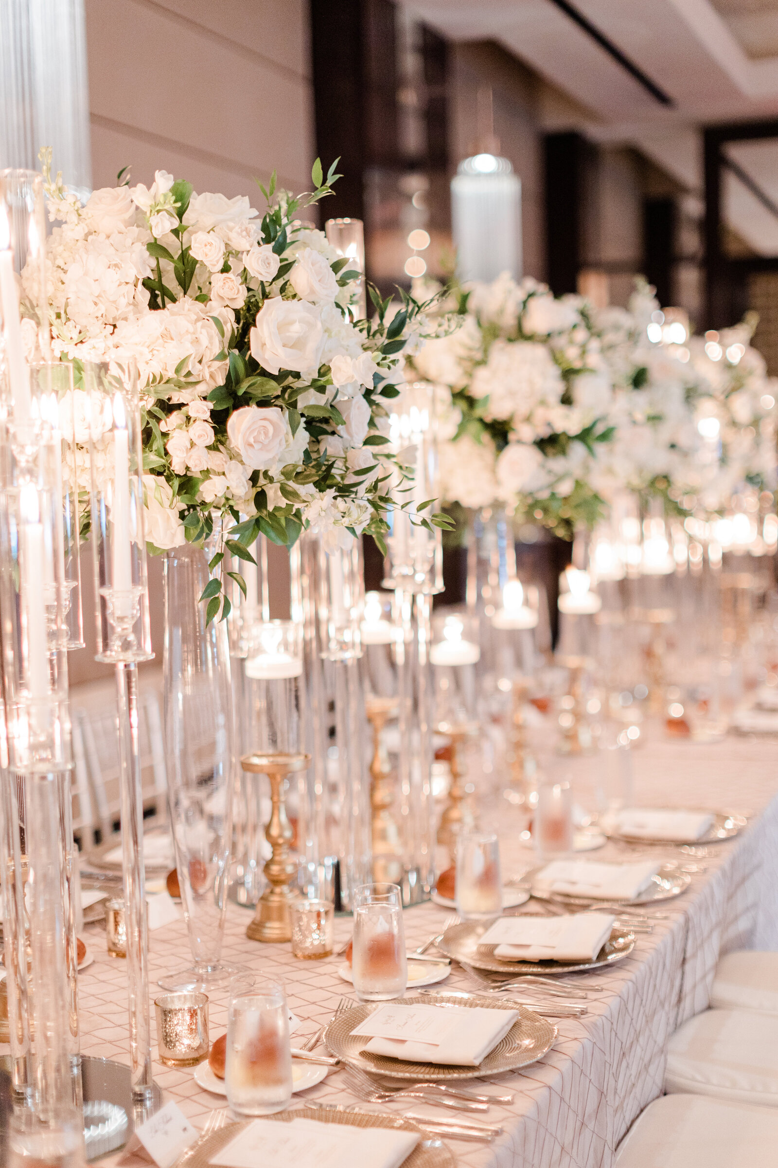 Reception table detail with gold candlesticks and warm candlelight