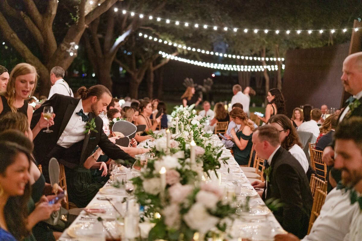 Al fresco reception dinner under warm string lights