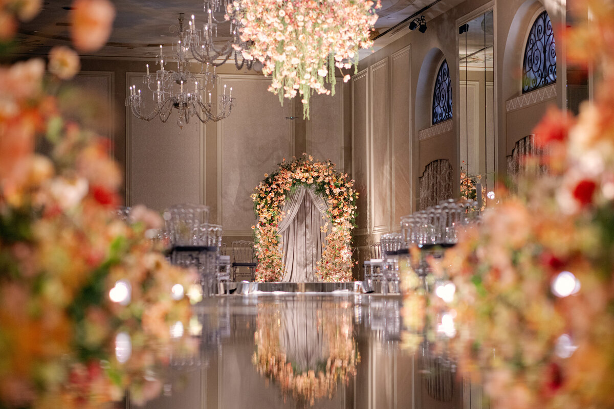 Cathedral-style ballroom ceremony with chandeliers and a grand arch
